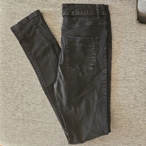 Svarta jeansbyxor - Snygga svarta jeansbyxor med en klassisk design. De har en bakficka och är perfekta för en stilren look. Passar bra till olika outfits och tillfällen.
