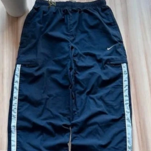 Vintage nike trackpants - Säljer nu dessa vintage Nike trackpants för 700. Storlek S/173, vilket gör att de passar någon mellan 163-174 cm beroende på hur du vill att de ska sitta och benlängd. Jag är 174 cm och de sitter bra på mig (be om bild). Dem är baggy av sig men inte alldeles för baggy, (kan justeras) enligt mig helt perfekta. De är vintage men i väldigt bra skick, utan hål eller fläckar. Enligt mig skulle jag säga mellan 7-8/10 i skick.Svårt att hitta bättre vintage skick.Hör av dig och be gärna om fler bilder. 