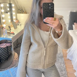 Beige teddyjacka H&M med dragkedja - Säljer denna trendiga mysiga beige teddyjacka från H&M med dragkedja framtill. Perfekt för kyliga dagar med sin fluffiga och varma design. Jackan har långa ärmar och en bekväm passform.  Använd ett fåtal ggr är i jätte bra skick!💓