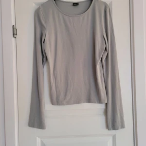 Grå-grön långärmad topp - Säljer en stilren grå-grön långärmad topp. Perfekt för lager-på-lager eller att bära som den är. Enkel design med rund halsringning.