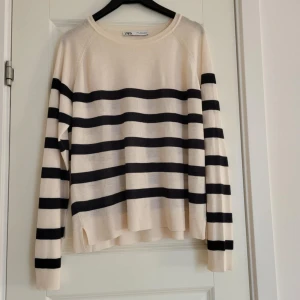 Randig tröja från Zara - Säljer en stilren randig tröja från Zara i svart och beige. Tröjan har långa ärmar och en avslappnad passform. Perfekt för en casual look.