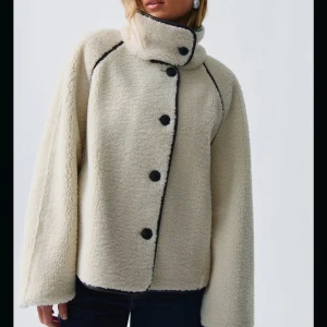 Beige teddyjacka med svarta detaljer - Säljer denna reversible teddy jacket ifrån ginatricot i storlek XS. Köpte den i oktober och har inte fått så mycket användning av den som jag önskat. Helt slutsåld på hemsidan! Nypris är 1000kr och jag säljer därför för 700kr. Skriv för egna bilder 🩷🩷🩷
