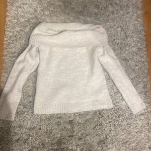 Vit offshoulder tröja från Gina Tricot - Säljer en beige offshoulder tröja från Gina Tricot. Tröjan har långa ärmar och en bred krage som ger en elegant look. Perfekt för kyligare dagar när du vill vara både bekväm och snygg. Passar bra till både jeans och kjol. Storlek 146/152