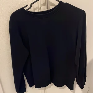 Svart långärmad tröja - Säljer en stilren svart långärmad tröja. Perfekt för en minimalistisk look och passar till det mesta i garderoben. Tröjan har en enkel design utan mönster eller detaljer.