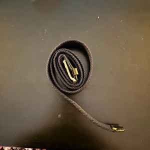 Marinblått bälte från Tommy hilfiger - Snyggt marinblått bälte med ett klassiskt metallspänne. Perfekt för att ge en stilren touch till din outfit. Bältet har en diskret logga och passar bra till både jeans och kostymbyxor.