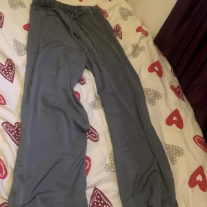 Grå mjukisbyxor från H&M - Säljer ett par bekväma grå mjukisbyxor från H&M. Byxorna har en elastisk midja för extra komfort och är perfekta för en avslappnad stil. Tillverkade i ett mjukt material som känns skönt