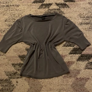 Grå tröja från Rill's - Säljer en stilren grå tröja från Rill's. Tröjan har trekvartsärmar och en rund halsringning. Perfekt för en avslappnad look. 