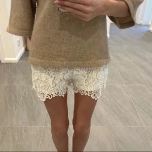 Vita spets shorts - Snygga vita shorts i storlek S med vacker spetsdetalj. Perfekt till sommar!!! De har en bekväm passform och är lätta att matcha t överdel. 