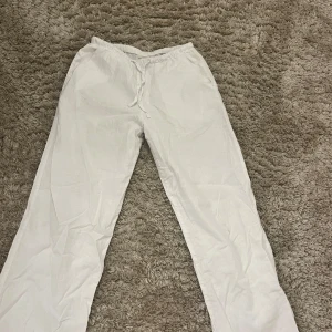 Vita linnebyxor från Gina Tricot !! - Säljer ett par vita linnebyxor från Gina Tricot. De har en bekväm elastisk midja med snörning och är tillverkade i ett lätt linne material. Perfekta för en avslappnad stil. Storlek 158/164.💞