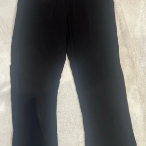 Svarta kostymbyxor från NA-KD x Hannalicious - Snygga svarta kostymbyxor från NA-KD x Hannalicious i storlek 38. Byxorna har en rak och lite loose passform med hög midja och klassisk look. Perfekta till en trendig och stilren outfit. Materialet känns mjukt och följsamt.