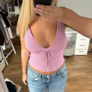 Ljusrosa linne  - Superfin ljusrosa stickat linne med smala axelband och v-ringning. Toppen har en söt snörningsdetalj framtill. Från Zara i storlek M. 