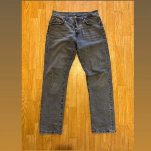 Grå raka jeans från Zara - Säljer ett par grå jeans från Zara med klassisk femficksdesign och raka ben. Jeansen har hög midja och stängs med knappar. Perfekta för dig som gillar en enkel och stilren look. Materialet är robust denim i bomull.