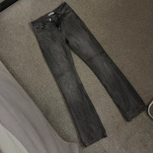 Mörkgrå raka jeans - Snygga mörkgrå bootcut jeans med klassisk femficksdesign. Jeansen har normal midja och är tillverkade i ett mjukt denimtyg som ger en avslappnad vibe. Perfekta till sneakers eller boots för en clean look.