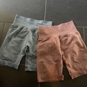 Träningsshorts - Två par träningsshorts med hög  Ena paret är blåa och det andra är i en röd aktig ton. Scrunch där bak