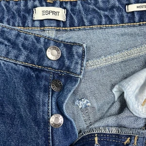 Esprit Western Bootcut Jeans blå - Snygga blå jeans från Esprit i modellen Western Bootcut. Klassisk femficksdesign, hög midja och raka ben med bootcut. Jeansen har knäppning med metallknappar och är gjorda i slitstarkt bomullsjeans. Perfekta för dig som gillar en tidlös look. Helt ny aldrig använd nytt pris 900kr