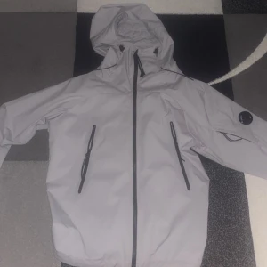 Grå vindjacka från C.P. Company - Cp company jacka, säljer den eftersom att den är för liten. Den är helt ny, nypris 4300kr storlek M