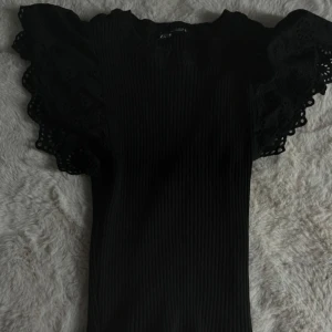 Svart ribbad topp med volangärm - Supersnygg svart topp från Zara! Har inte kommit till användning, passar xs och s!❤️