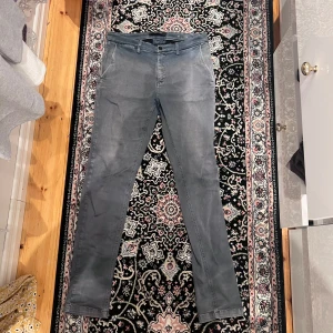 Replay Zeumar grå chinos,  32/32 - Snygga grå chinos från Replay i modellen Zeumar. Byxorna har raka ben, klassiska sidfickor och bakfickor med knapp. Skön passform och stilren look, perfekta till en avslappnad men ändå uppklädd outfit.