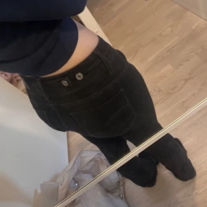 Svarta bootcut jeans från G-Star - Säljer ett par svarta jeans från G-Star med bootcut passform och låg midja. Jeansen har klassiska fickor, snygga detaljer med dubbla knappar bak och G-Star-logga framtill. Materialet är stretchigt jeans för en bekväm känsla. Jag är 167cm pris kan diskuteras
