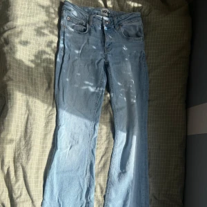 Bootcut ljusblå jeans från 157 - Snygga ljusblå jeans från 157 med klassisk femficksdesign och bootcut-ben. Jeansen har normal passform och är tillverkade i mjukt denimtyg som sitter skönt hela dagen. Perfekt för dig som gillar en retro vibe och vill ha ett par jeans som sticker ut.