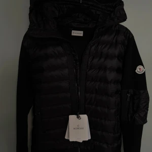 Monclear cardigan - En svart monclear cardigan me monclear lapparna med väldigt varm så passar bra till höst och vinter den har också väldigt bra passform