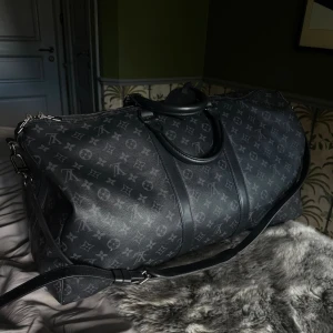 Louis Vuitton Keepal 55 - Louis Vuitton Keepall Bandoulière 55 i Monogram Eclipse Canvas, som ny. Nypris 30’000