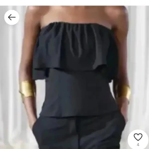 Svart Zara topp med volang  - 😇Högt pris då ja är osäker om ja vill sälja .😇Säljer en svart bandeau tubtopp med bred volang upptill. Toppen är axelbandslös och har en tight passform som framhäver midjan. Perfekt för dig som vill ha en stilren och trendig look. Materialet känns mjukt och följsamt.