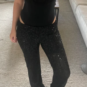 Svarta paljettbyxor med rak passform - Säljer ett par svarta byxor täckta med glittrande paljetter. Endast använd en gång! Såå snygga till utgångar och nyår🤍
