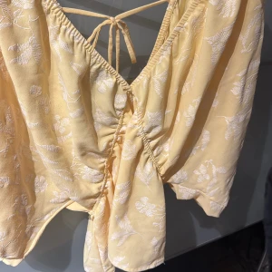 Gul blus zara - Säljer den populära superfina gula blusen med vit broderade detaljer med öppenrygg ifrån Zara nu eftersom den inte kommer till användning!