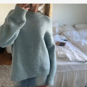 Ljusblå stickad tröja - Supermysig ljusblå stickad tröja med oversized känsla och breda ribbade muddar vid ärmslut och hals. Perfekt för lager-på-lager och chill dagar. Tröjan har lång ärm och en enkel, stilren look som passar till allt.