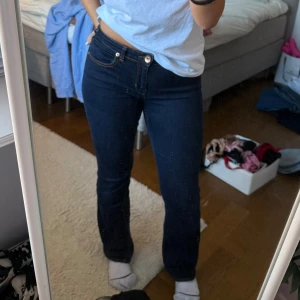 Mörkblå bootcut jeans med broderade fickor - Säljer dessa mörkblå jeansen som är köpta secondhand. Har sytt in de i midjan men går att ta bort om man vill💕Även kortat ner de på längden som också går att sprätta upp