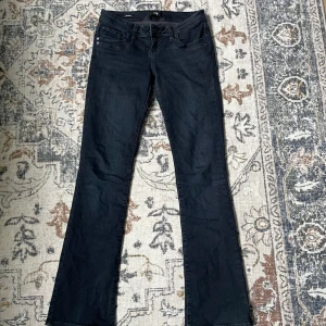 Mörkblå bootcut jeans - Snygga mörkblå jeans med bootcut-modell och klassisk femficksdesign. Jeansen har en stilren look och är perfekta för dig som gillar en lite utsvängd passform nertill. Tillverkade i ett mjukt och stretchigt jeansmaterial.