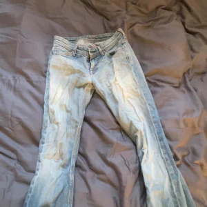 Ljusblå bootcut jeans från 7 For All Mankind - Ljusblå jeans med bootcut från 7 For All Mankind. Klassisk femficksmodell med slitningar och broderade bakfickor. Jeansen har en något utsvängd passform och är tillverkade i bomull med snygg tvättad look. Hål i skrevet men går att sy, stygnen som redan är syns inte mycket när man har på sig dom