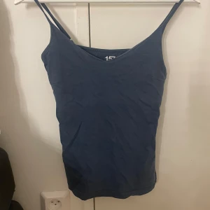 Mörkblå linnetopp med smala axelband - Mörkblått linne från lager 157 med smala axelband och v-ringning. 