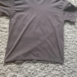 Grå t-shirt från Stone Island - Snygg grå t-shirt från Stone Island med klassisk rund hals och korta ärmar. T-shirten har den ikoniska Stone Island patchen på ena ärmen, vilket ger en cool och exklusiv vibe. Materialet är mjukt och känns skönt mot huden, perfekt för chill dagar, pris kan diskuteras.