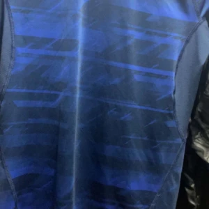 Real Madrid svart fotbollströja Adidas - Säljer en svart Real Madrid fotbollströja från Adidas med vit krage och vita ränder på axlarna. Tröjan har ett stort drakmotiv framtill och Fly Emirates-tryck. Materialet är lätt och andas, perfekt för match eller träning.