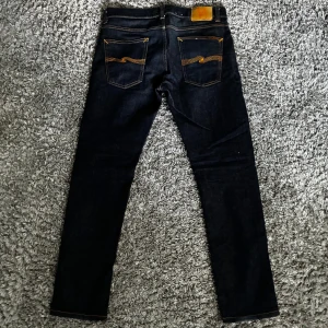 Mörkblå jeans från Nudie - Mycket snygga mörkblå nudie jeans som fadear med tiden, otroligt bra skick, inga skador för har använt få gånger.
