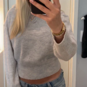 Ljusgrå stickad hoodie från Gina Tricot - Supermjuk ljusgrå stickad hoodie från Gina Tricot med croppad passform. Tröjan har huva med snörning och långa ärmar. Denna stickade hoodie är i str 158-164 men passar mig som har xs-S hur bra som helst❤️( den är nästintill oanvänd)