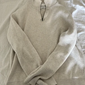 Beige stickad half zip-tröja These Glory Days - Snygg beige stickad tröja från These Glory Days i storlek S. Tröjan har en hög krage med half zip-dragkedja och långärmad passform. Perfekt för lager-på-lager och chill höst- eller vinterstil.