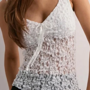 Vit spetsig linnetopp med knyt - Säljer en vit ärmlös linnetopp i spets med v-ringning och söt knytning framtill. Skriv gärna om man vill ha fler bilder🤍