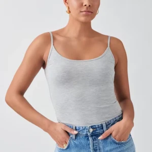 Ljusgrå linnetopp med smala axelband - Säljer en stilren ljusgrå linnetopp med smala axelband och rundad halsringning från Gina Tricot. Toppen är figurnära om i ett väldigt sköns tyg. Helt oanvänt. 