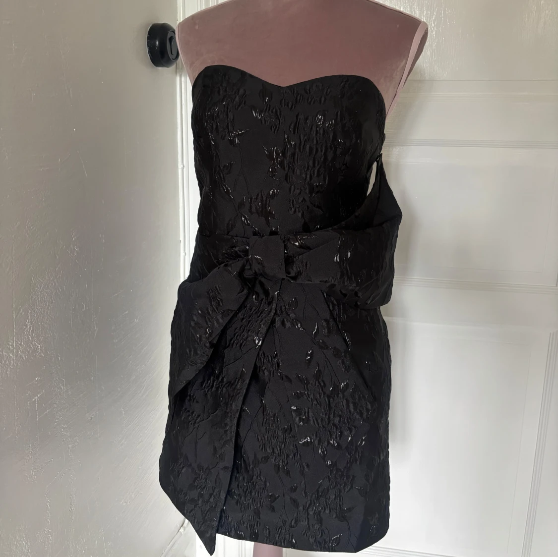 Svart axelbandslös kortklänning med rosett