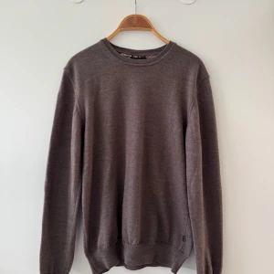 Merinoull tröja från Sand  - Snygg brun tröja från Sand Copenhagen. Tröjan har rund halsringning, långa ärmar och en klassisk passform. Perfekt för lager-på-lager och funkar till både jeans och chinos. Materialet är mjukt och skönt mot huden. 1300 nypris. 