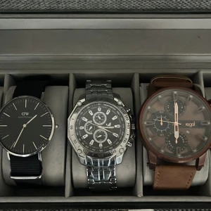 Tre herrklockor (Behöver byta batteri) - Säljer tre stilrena herrklockor: en svart Daniel Wellington med svart tygarmband, en sportig Oriando med silverfärgat metallarmband och svart urtavla samt en brun Regal med brunt läderarmband och brun urtavla. Perfekta accessoarer för att lyfta din stil. Alla behöver byta batteri. Pris diskuteras 