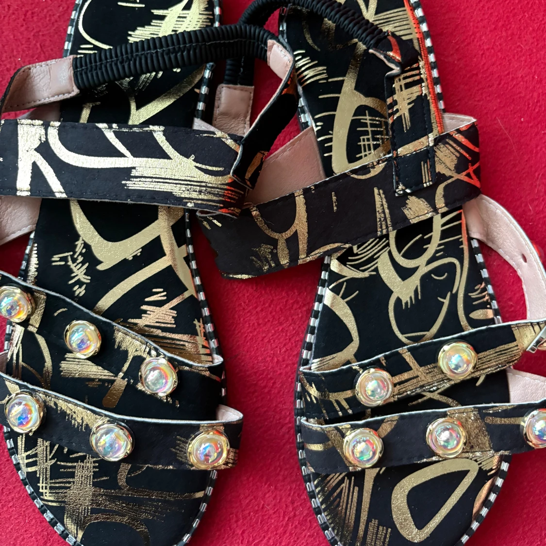 Svarta sandaler med guldmönster och pärlor