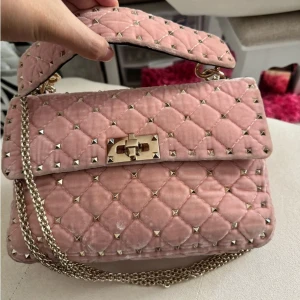 Rosa valentino garavani rockstud väska - Superfin rosa valentino garavani rockstud. Köpt på vestaire så därmed är den äkta! Köpt för 900€ (9879 kr)❤️Har tecken på använding!🥰