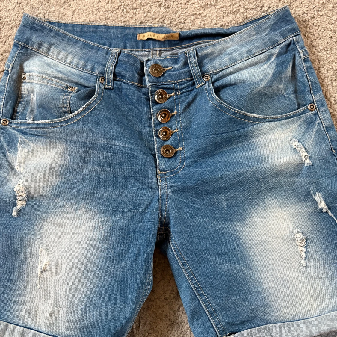 Blå jeans med slitningar och stjärndetalj