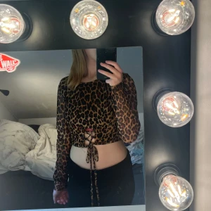Leopardmönstrad cropp topp - Crop topp från madlady med leopard mönster och snörning. Materialet är genomskinligt förutom i fram 💕 inte så använd och i fint skick 