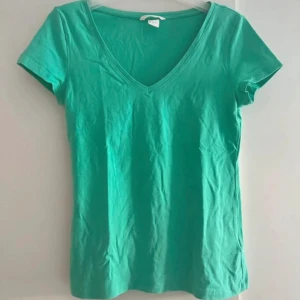 Grön v-ringad topp - Enkel grön t-shirt med v-ringning och korta ärmar. Skön passform. Perfekt till jeans eller shorts. Snygg basic som funkar året runt
