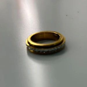 Guldfärgad ring som hjälper med stress  - Jättesnygg guldfärgad ring med en rad glittrande stenar runt hela bandet. Den är från märket ASTRID och går att rotera på mellan insidan och utsidan. Den är för att hjälpa mot stress och jag älskar den. Råkade dock beställa två men insog försent så kunde inte skicka tillbaks! Dethör är så såklart den oanvända! Köptes för 350.